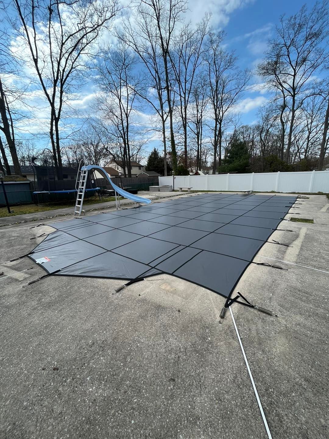 A swimming pool cover is sitting on top of a concrete surface.