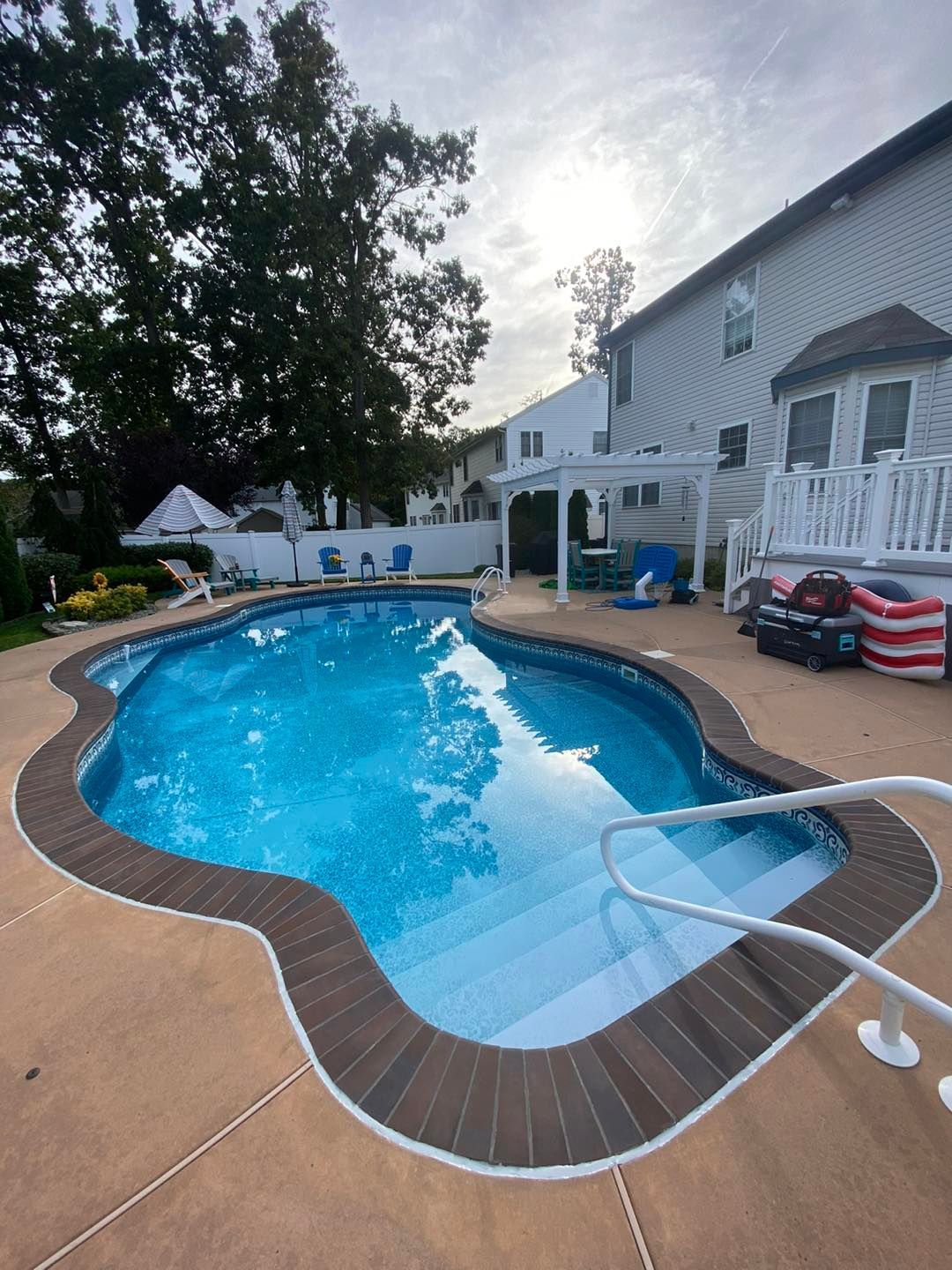 There is a large swimming pool in the backyard of a house.