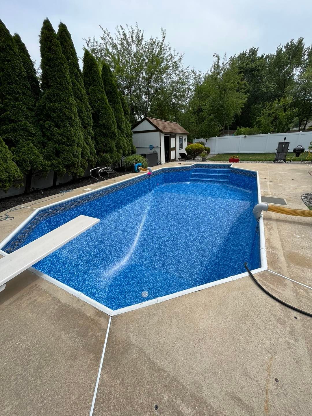 A large swimming pool with a diving board in the middle of it.