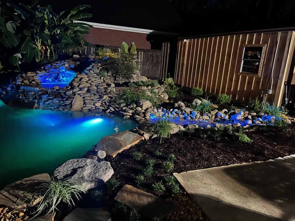 A swimming pool is lit up at night with blue lights.