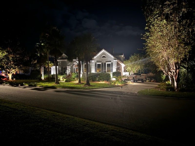 A house is lit up at night in a residential neighborhood.