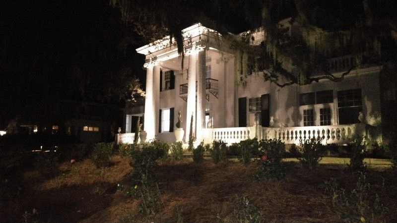A large white house is lit up at night