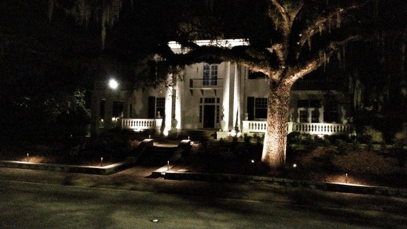 A large white house is lit up at night