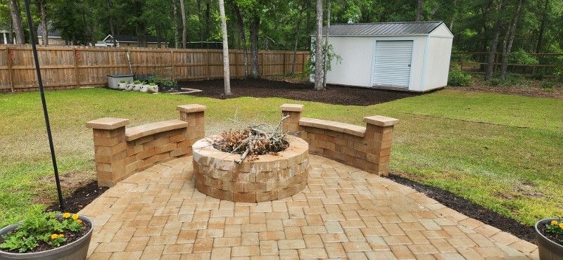 There is a fire pit on the patio in the backyard.
