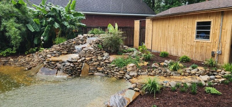 There is a waterfall in the backyard of a house.
