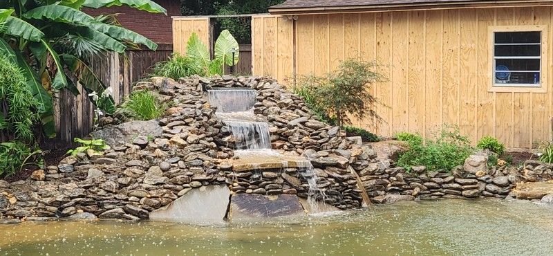 There is a waterfall in the backyard of a house.