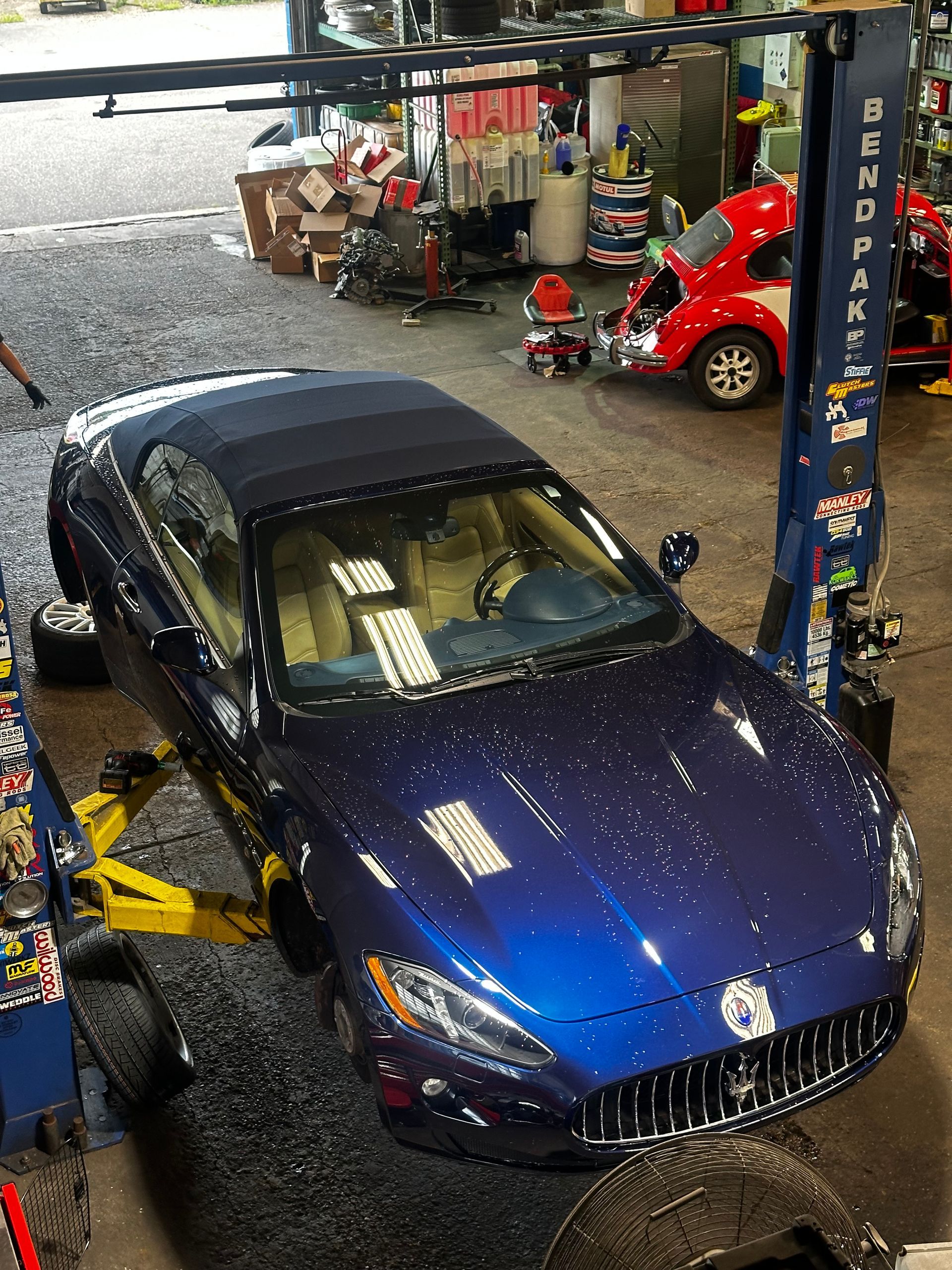 A blue car is sitting on a lift in a garage