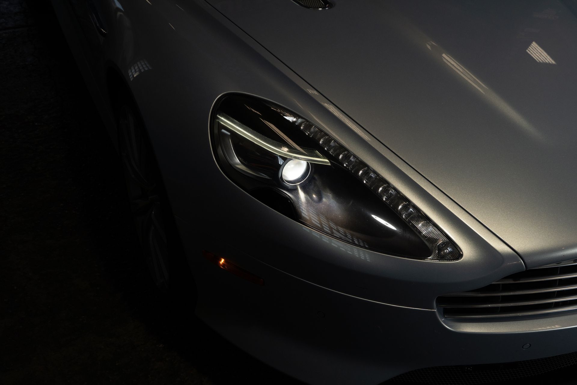 A close up of a car's headlight in the dark