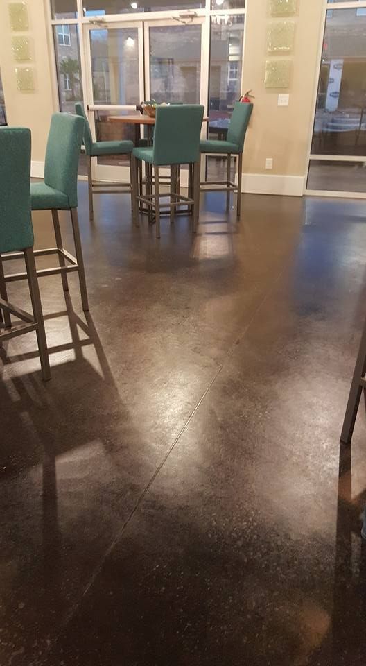 Polished dark floor with turquoise chairs around tables, interior setting.