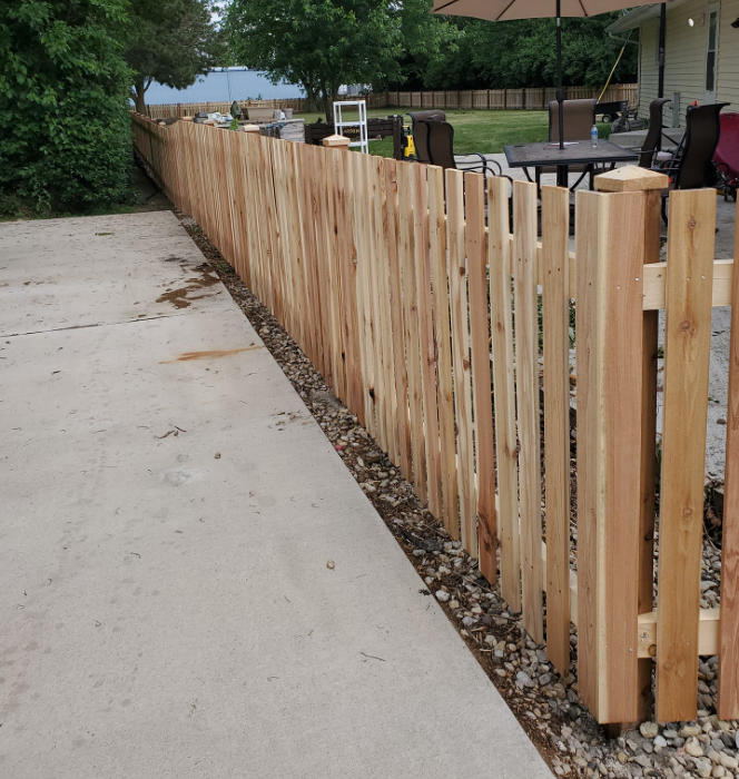 A wooden fence along the side of a driveway