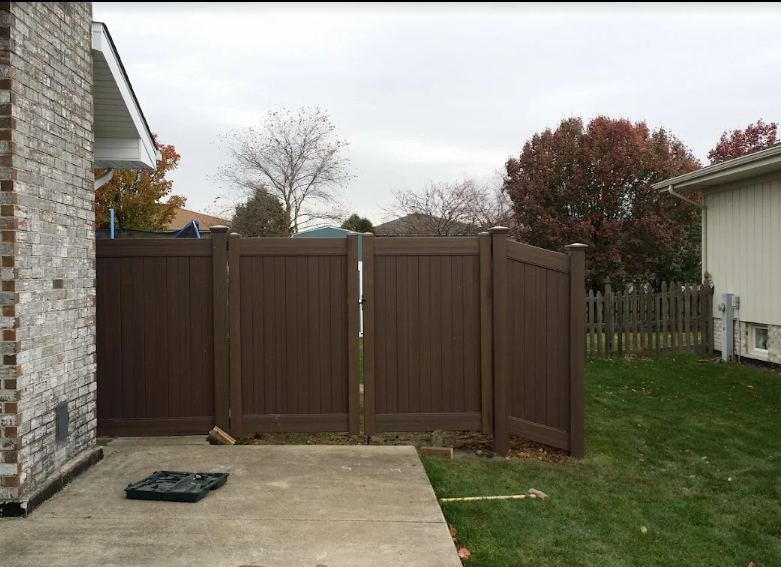 A brick house with a brown fence in front of it