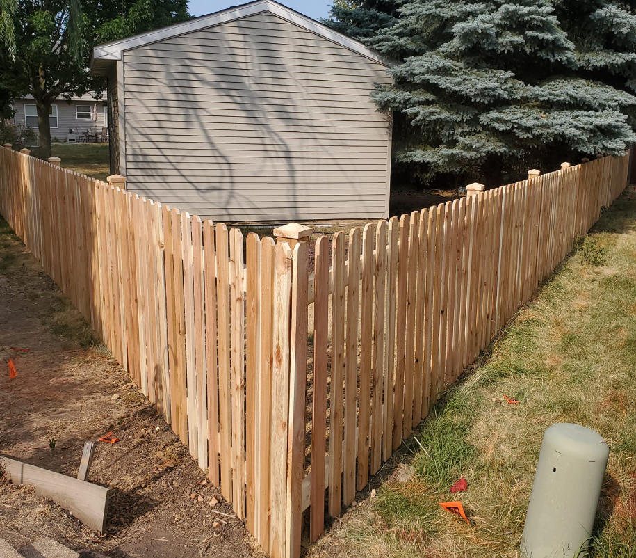 A wooden fence with a house in the background