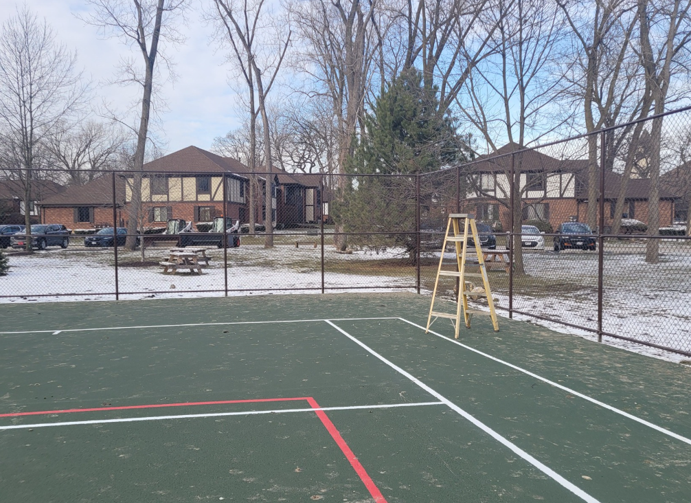A tennis court with a ladder in the middle of it