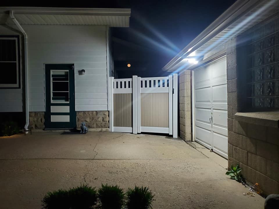 A house with a gate and a garage at night