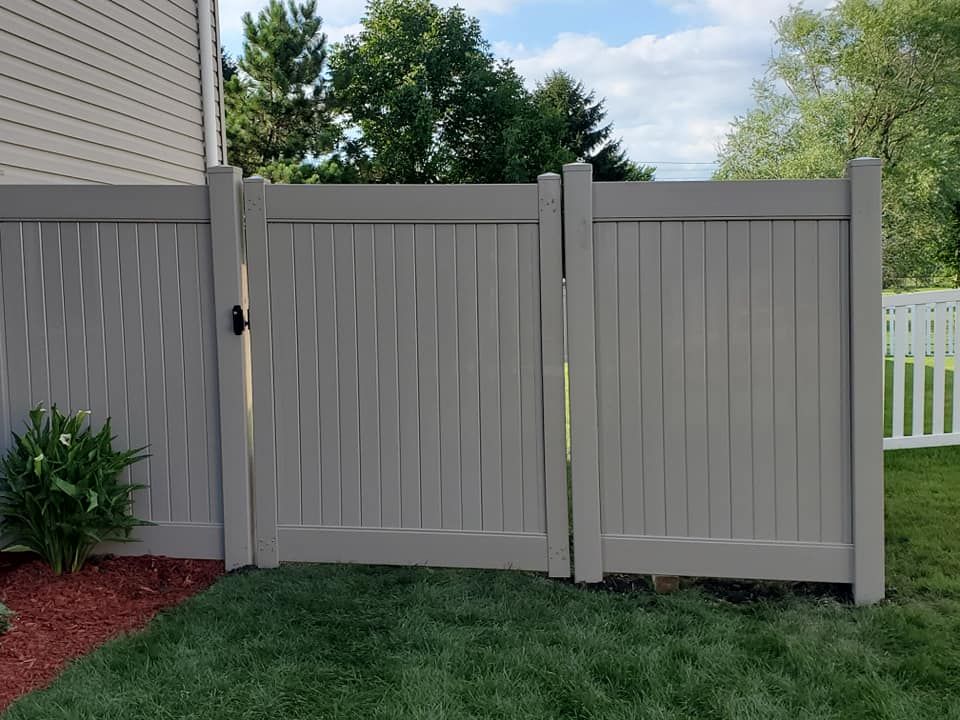 A white fence with a gate in the backyard
