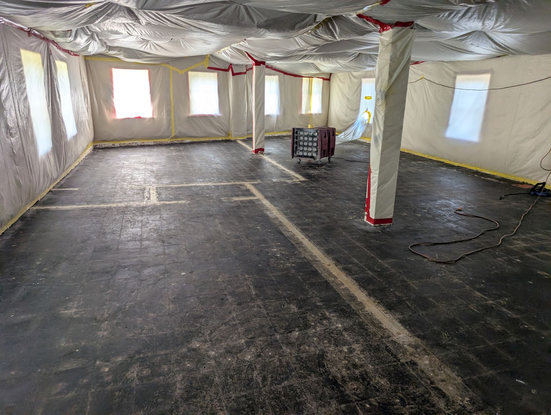 A large room with a lot of windows and a black floor