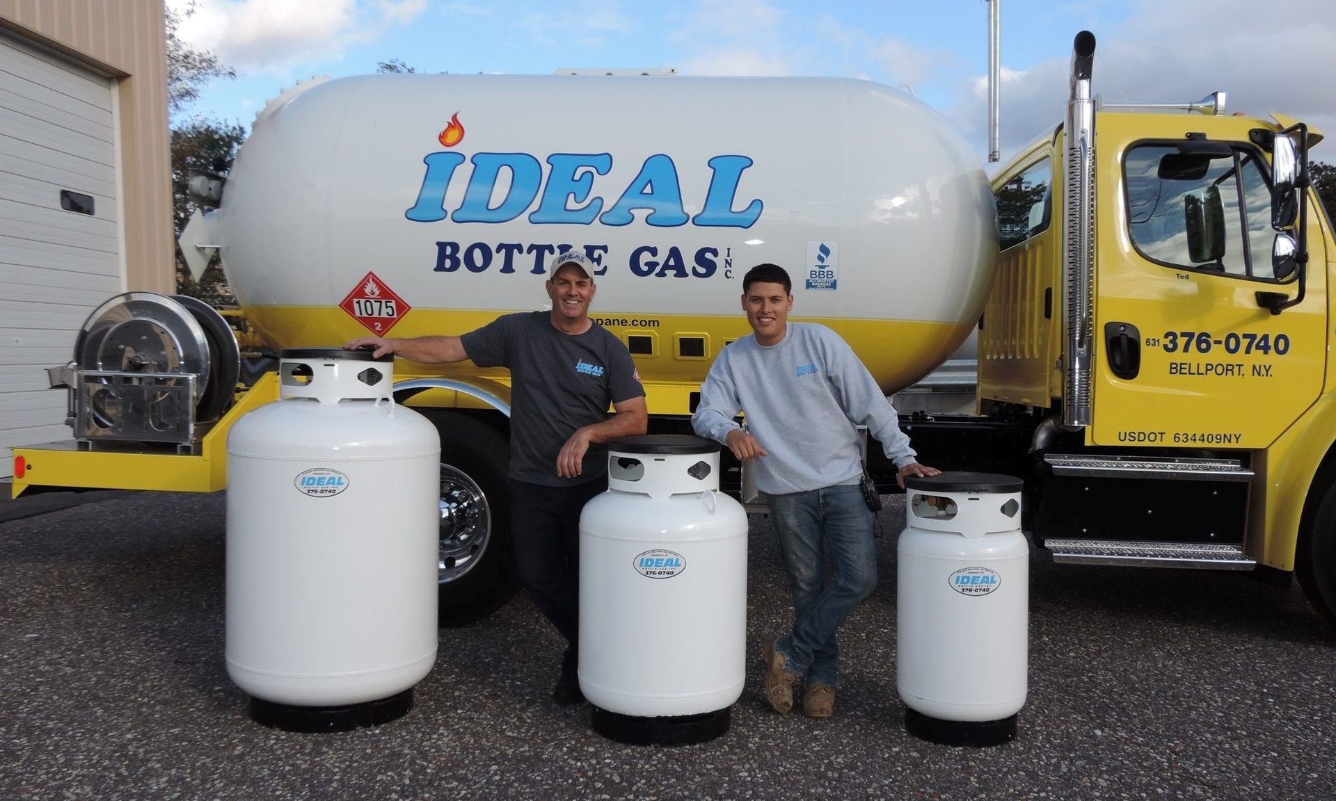 two owners standing with the propane tanks and truck