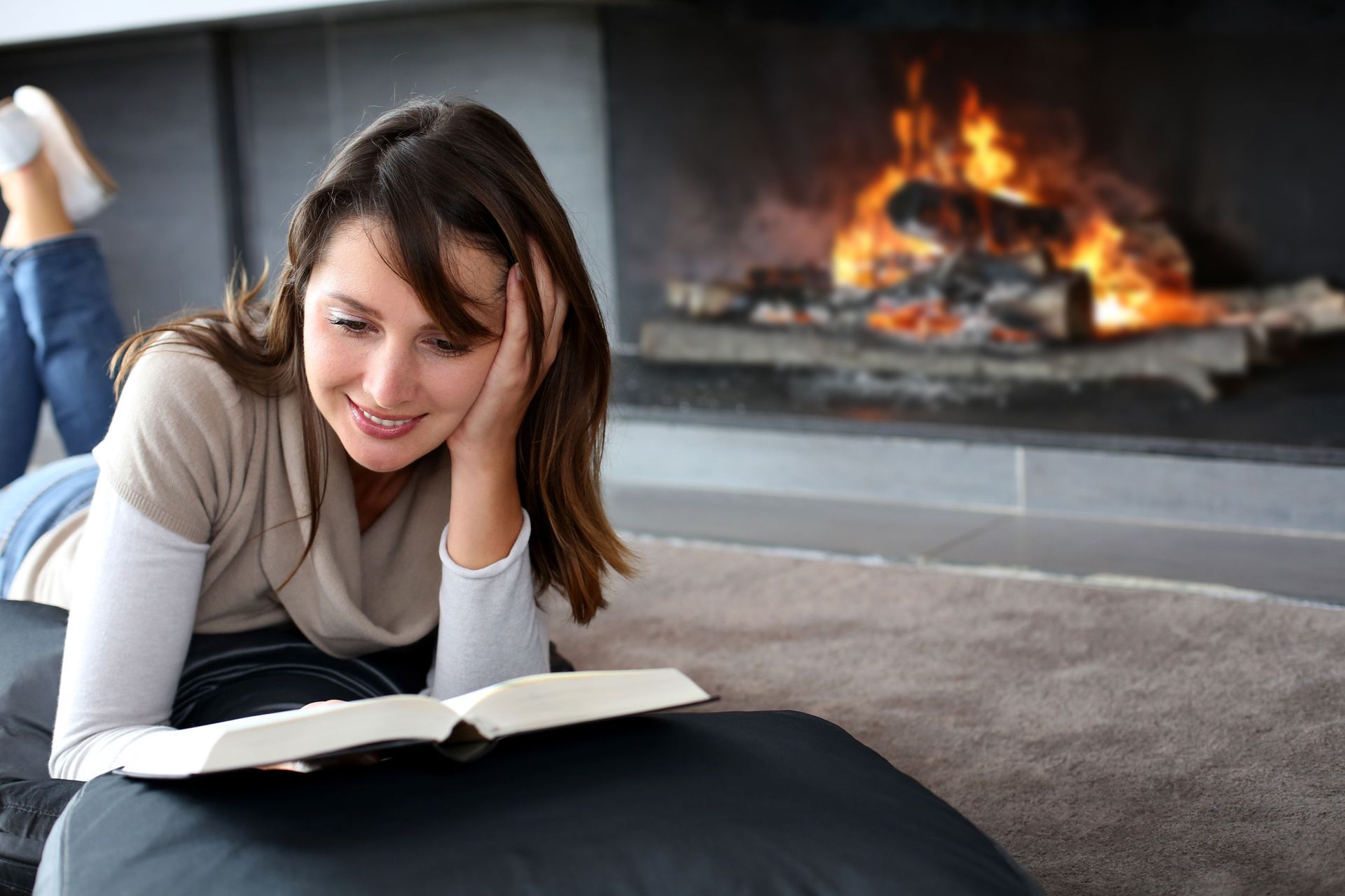 lady reading a book with fireplace in the background