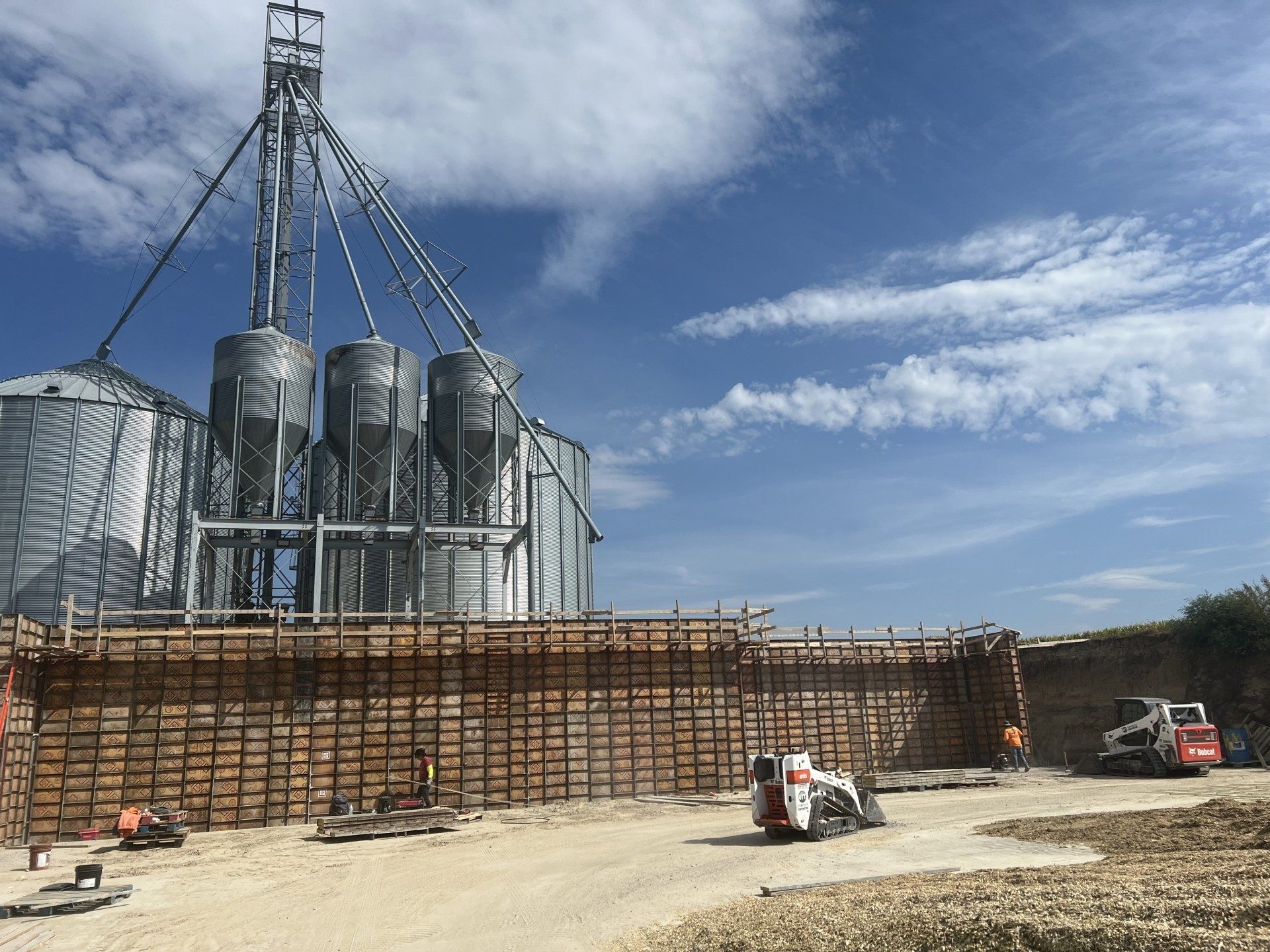 A construction site with a lot of silos in the background