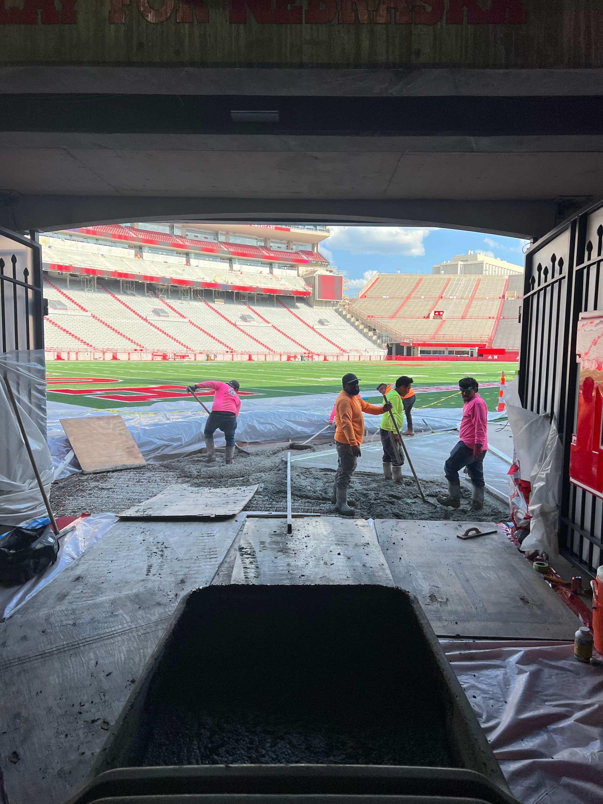 A group of people are working on a stadium floor
