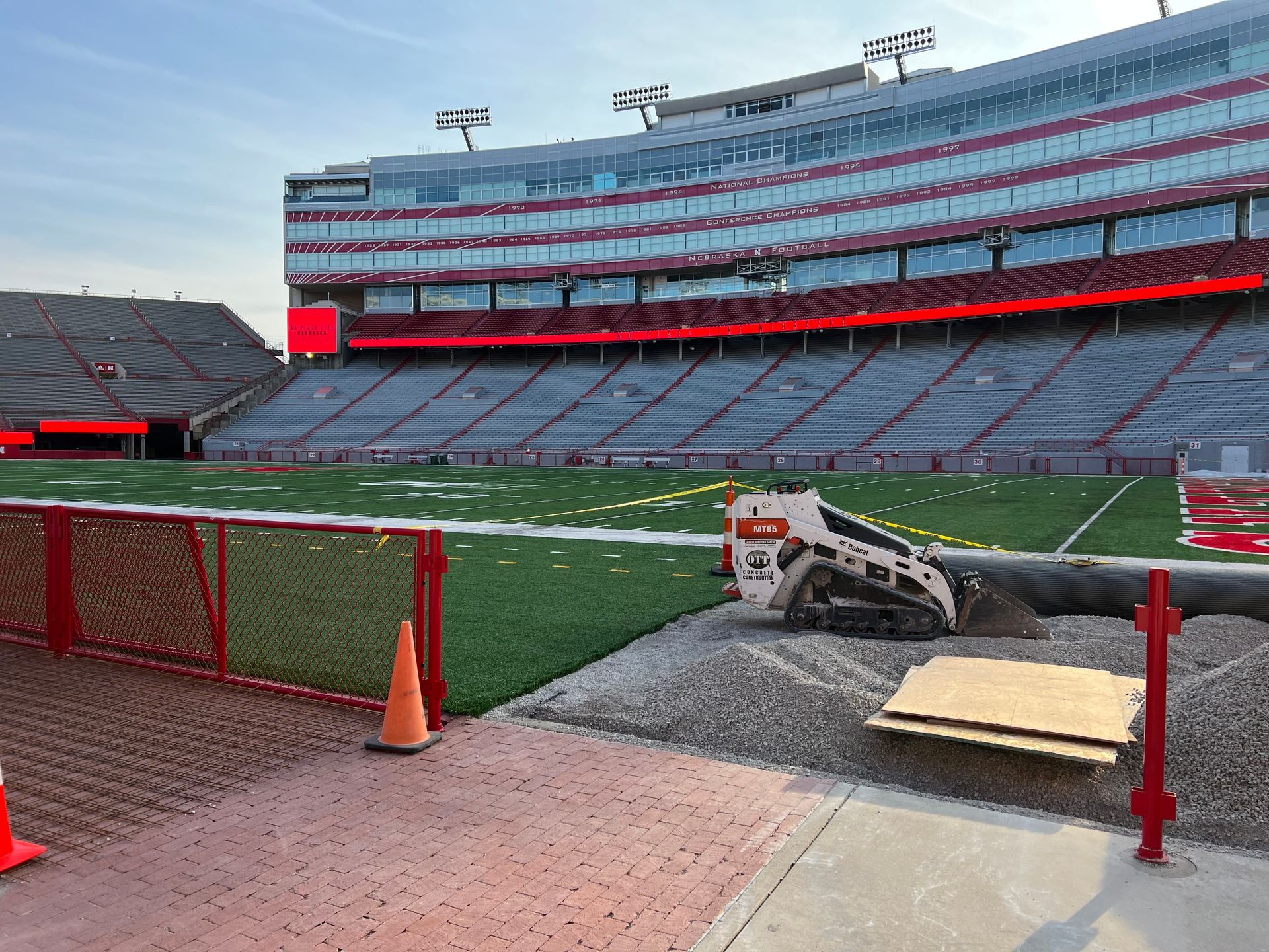 A bulldozer is parked on the side of a football field