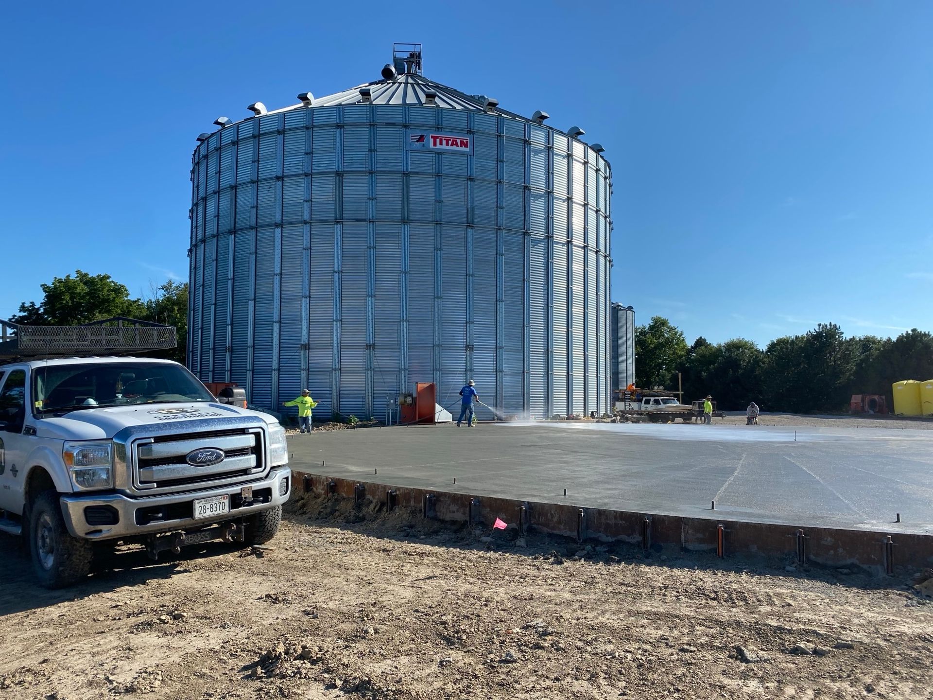 A pavement in front of a large metal silo