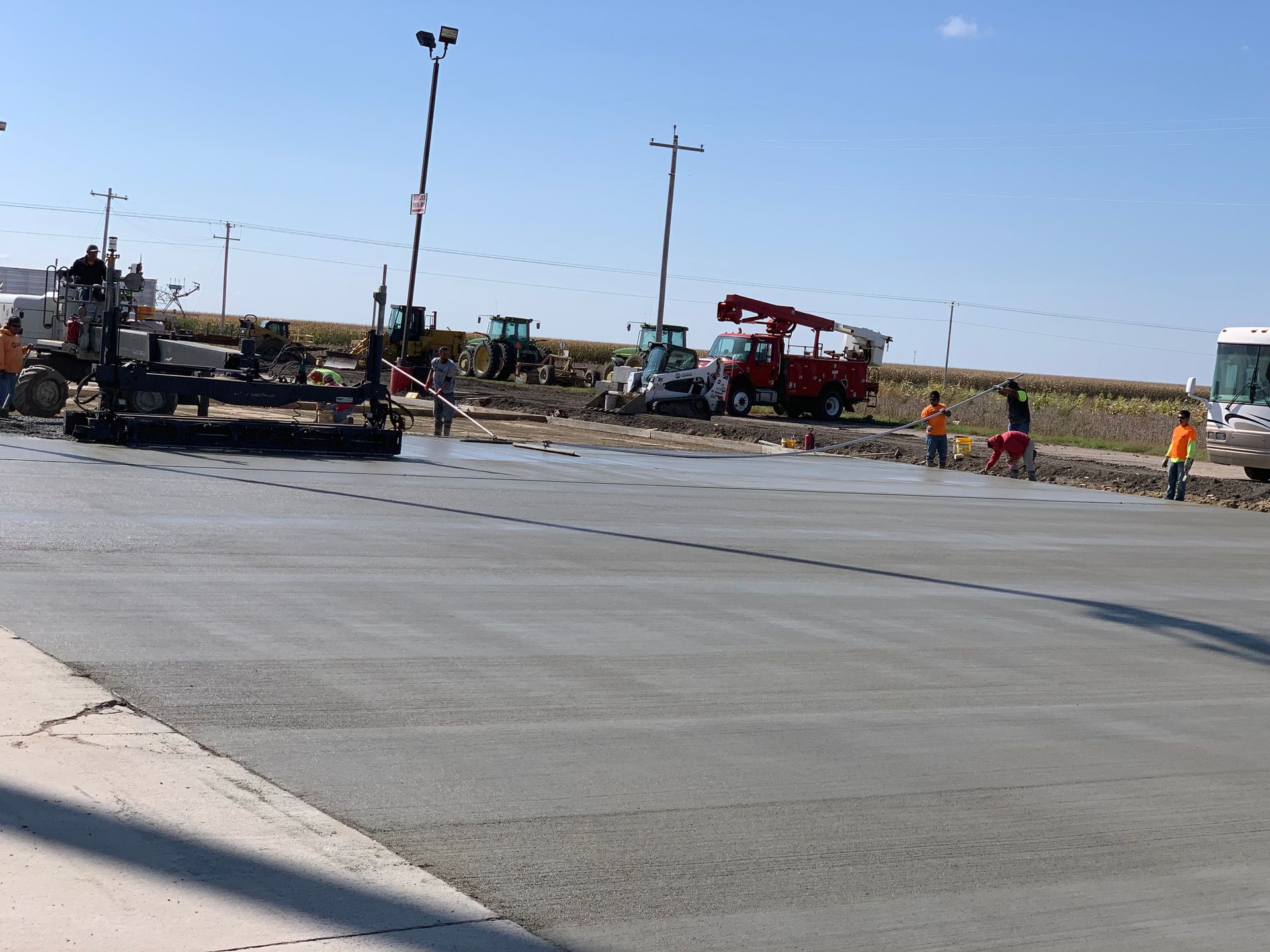 A group of construction workers are working on a concrete road
