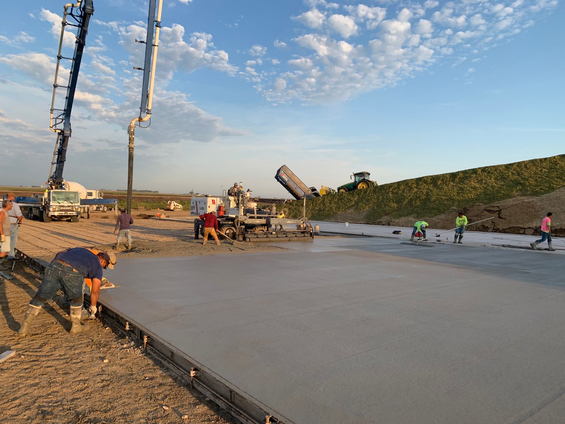 A group of construction workers are working on a concrete paving