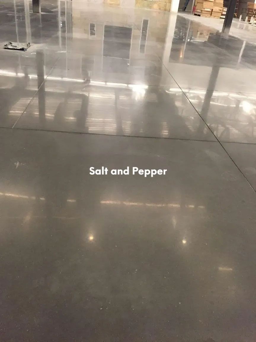 Polished concrete floor with salt-and-pepper design, reflecting ambient light in a warehouse.
