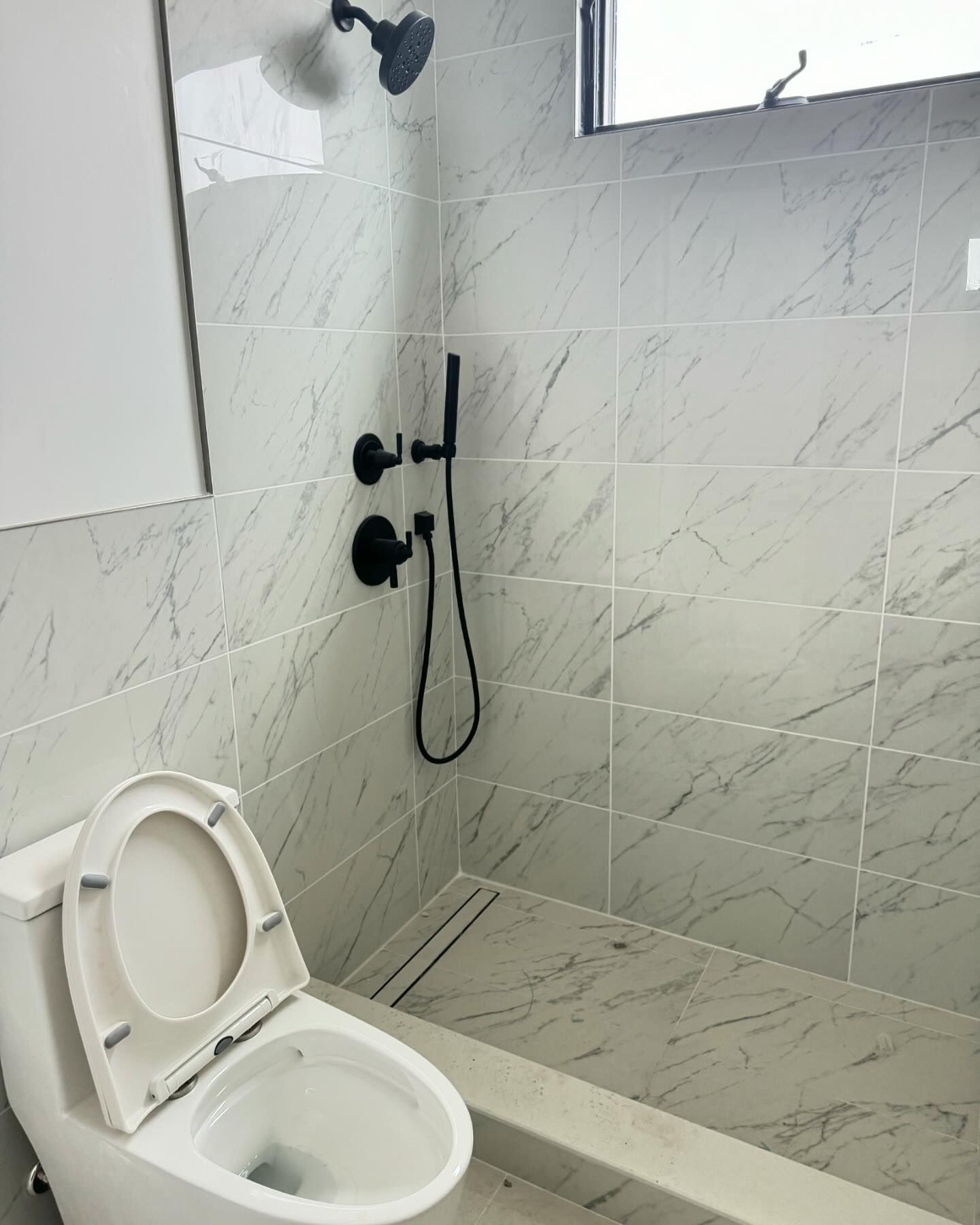A bathroom with a toilet and a shower.