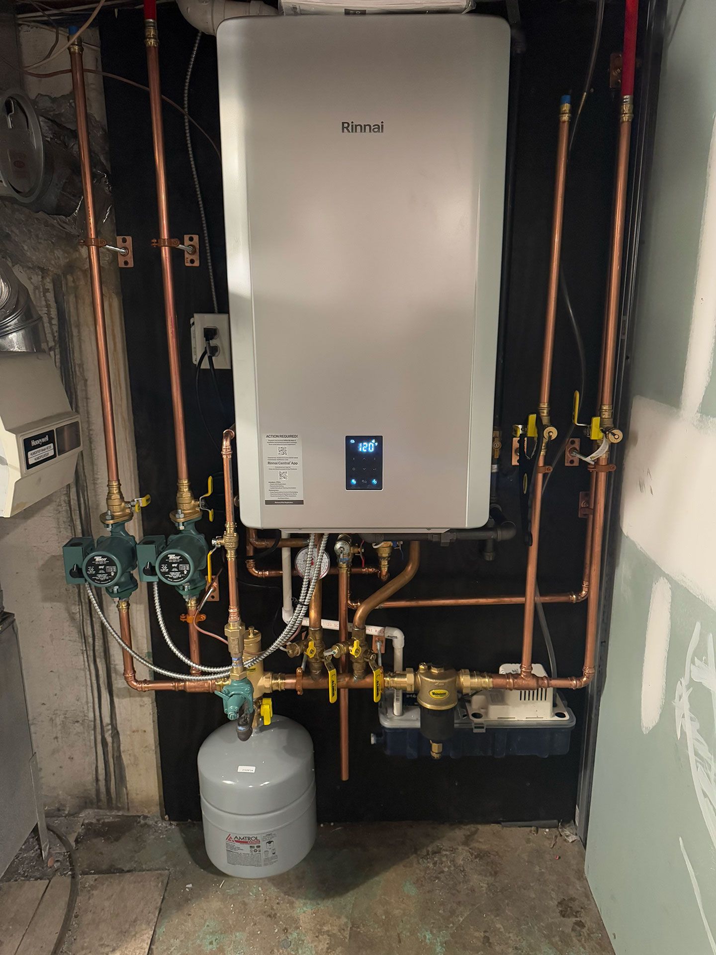 A boiler is installed in a room with copper pipes.