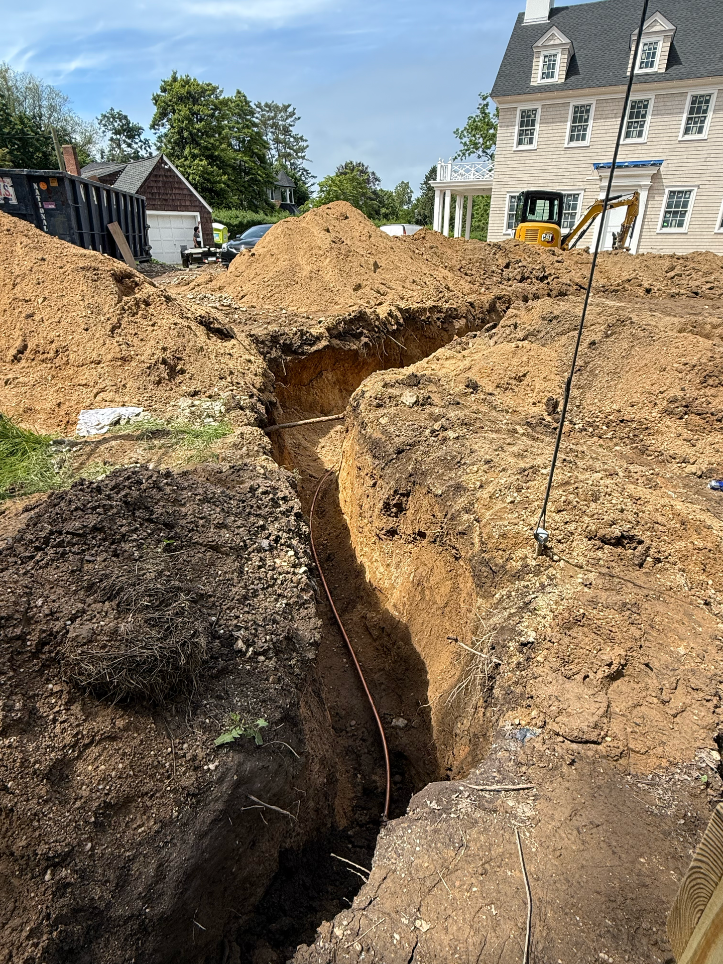 A large pile of dirt is sitting in front of a house.