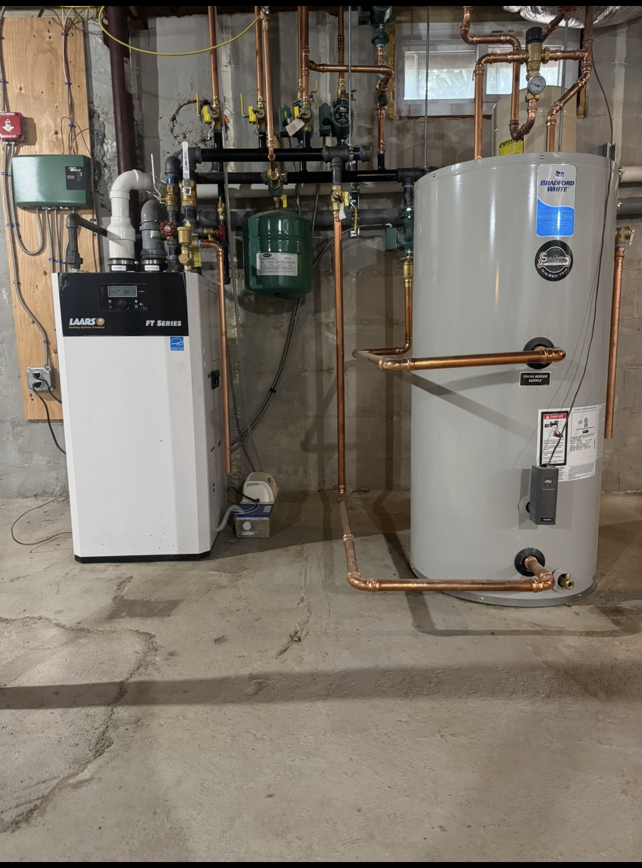A water heater and a gas heater are in a basement.