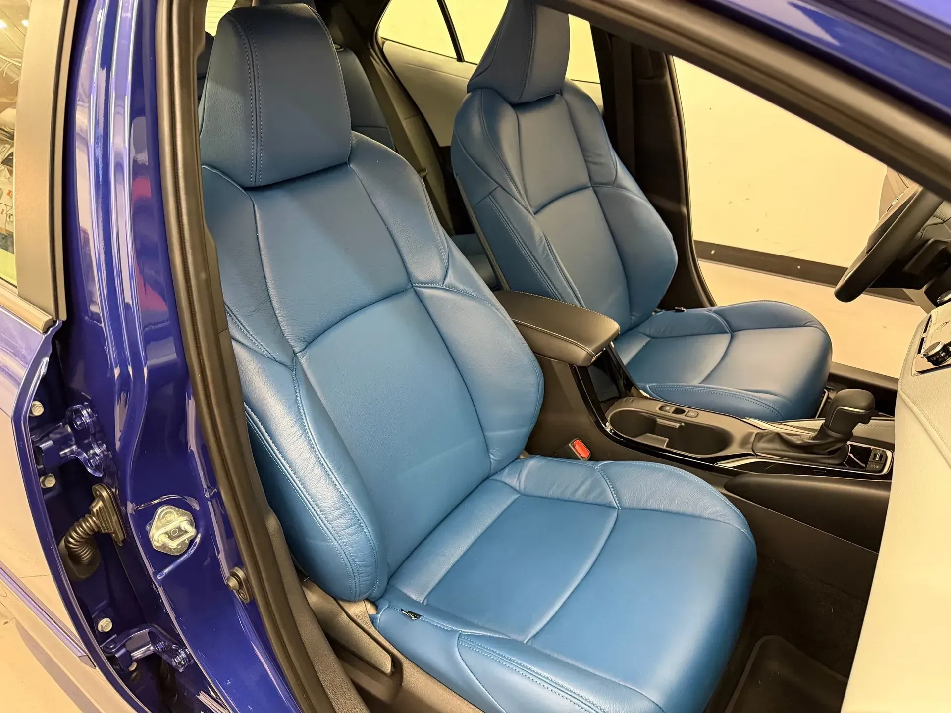 Blue leather car seats, visible from the open door.