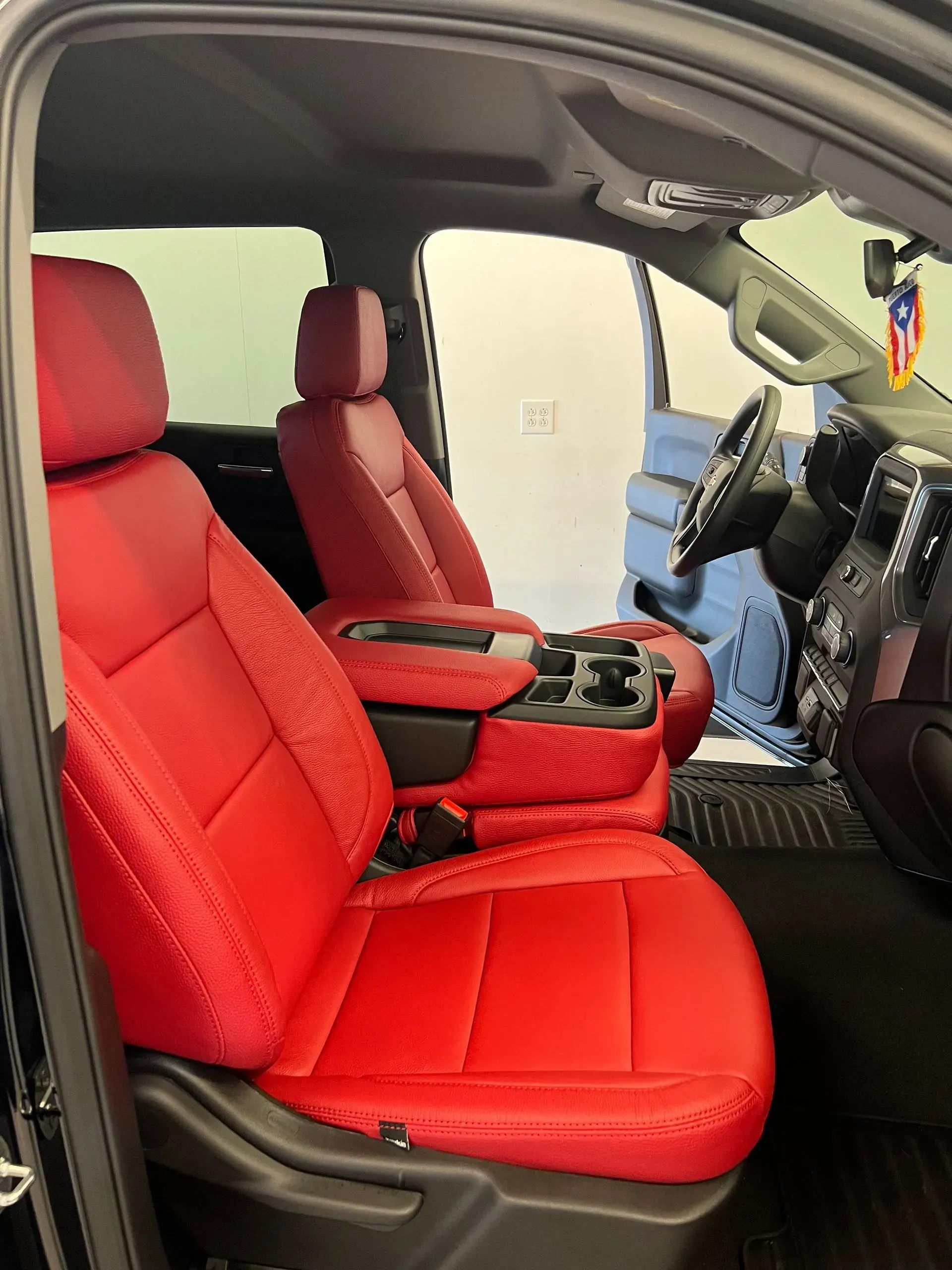 Red leather car interior with center console, steering wheel visible.