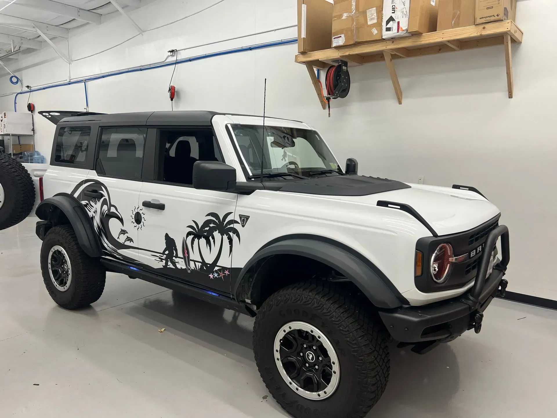 White Ford Bronco with black accents and a beach-themed graphic.