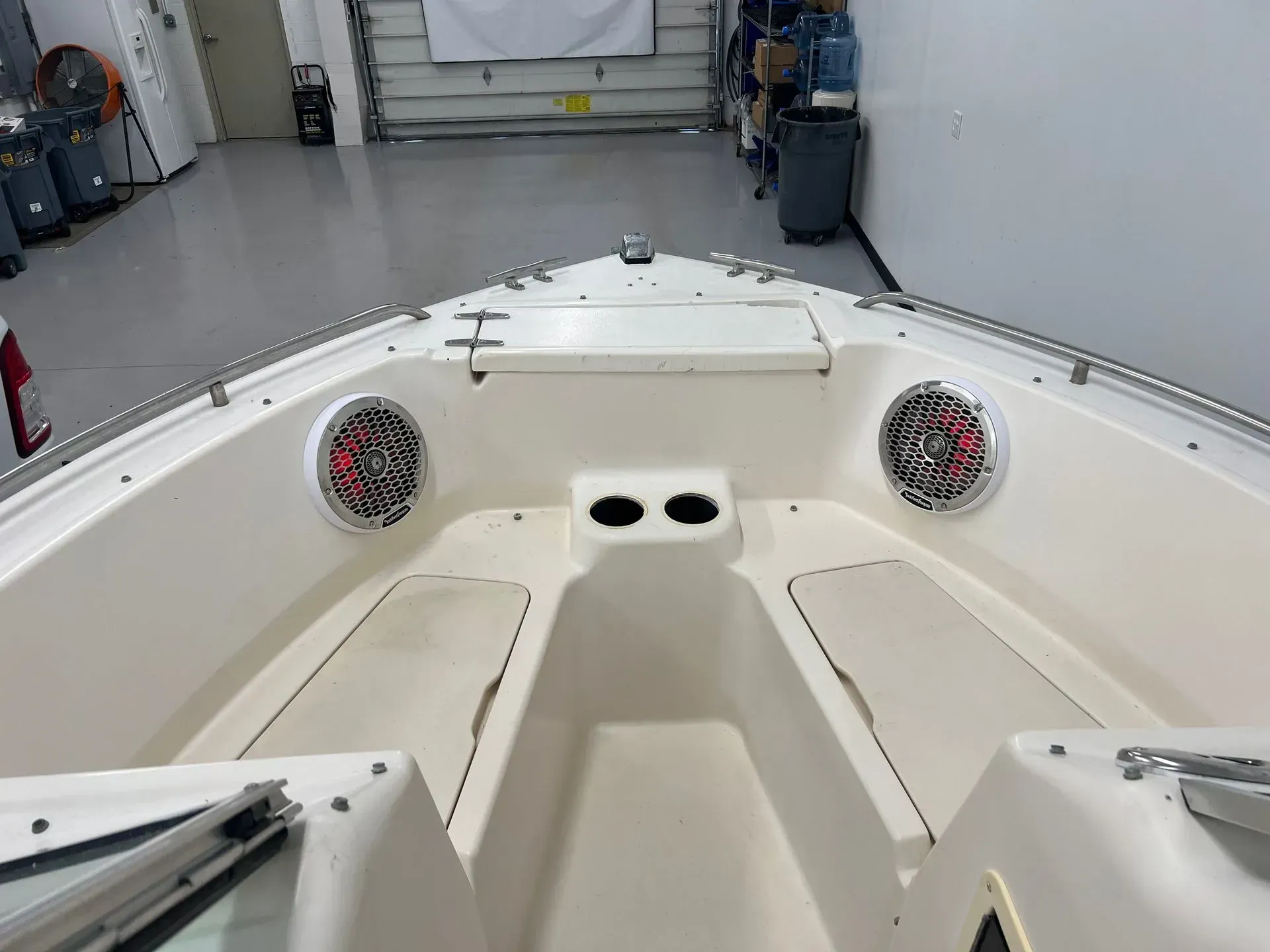 Interior view of a boat, showing speakers, cup holders, and seating.