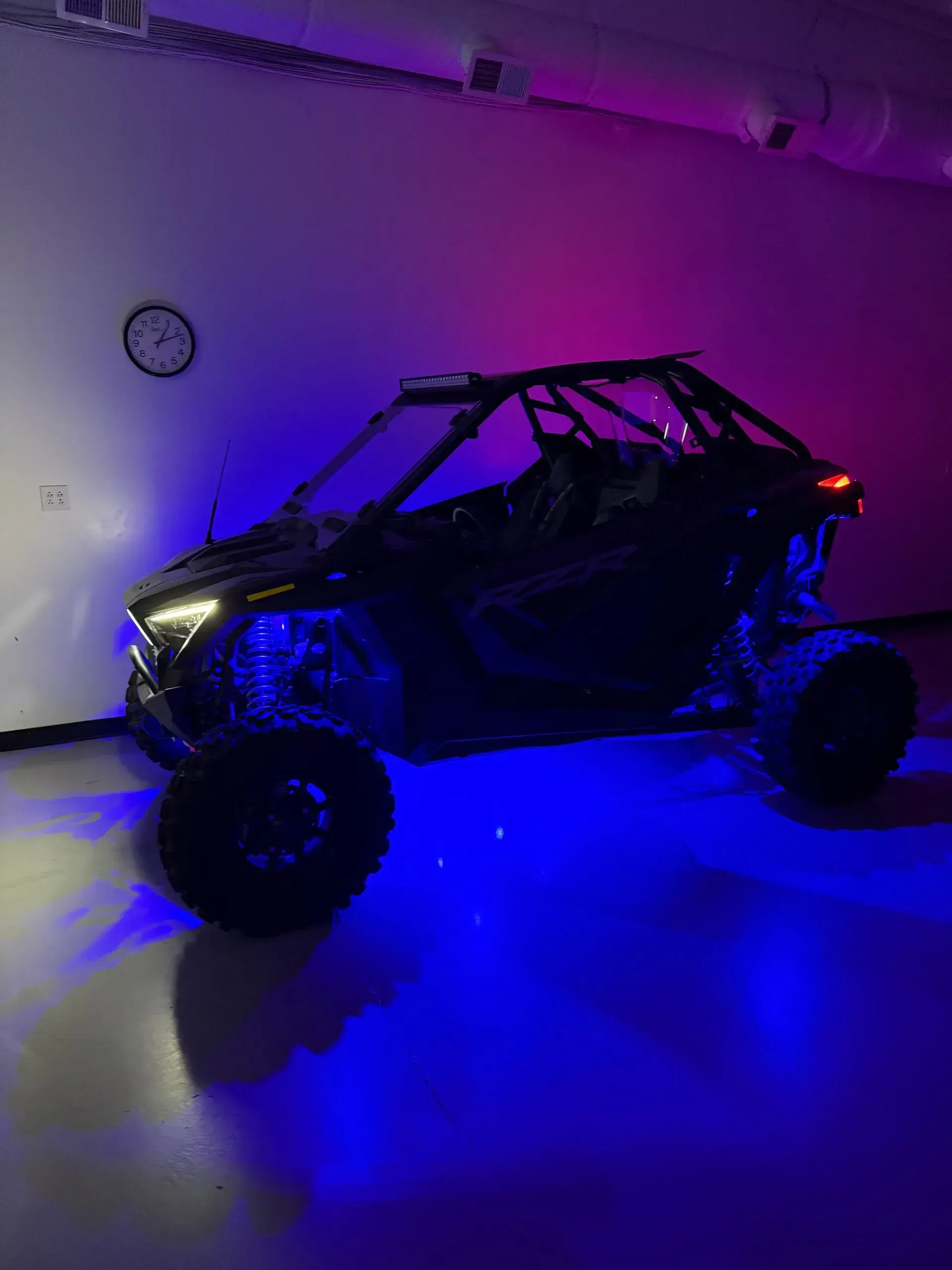 Black UTV in a room with blue and purple lighting.