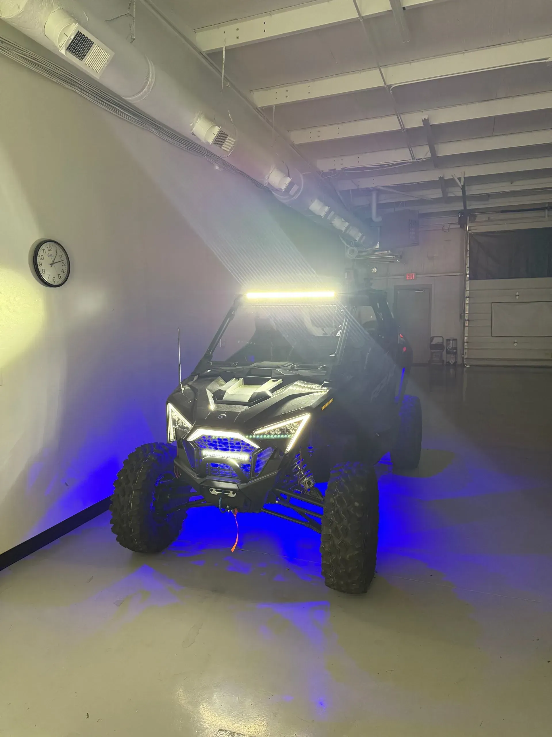 Black ATV with blue and white lights inside a building.