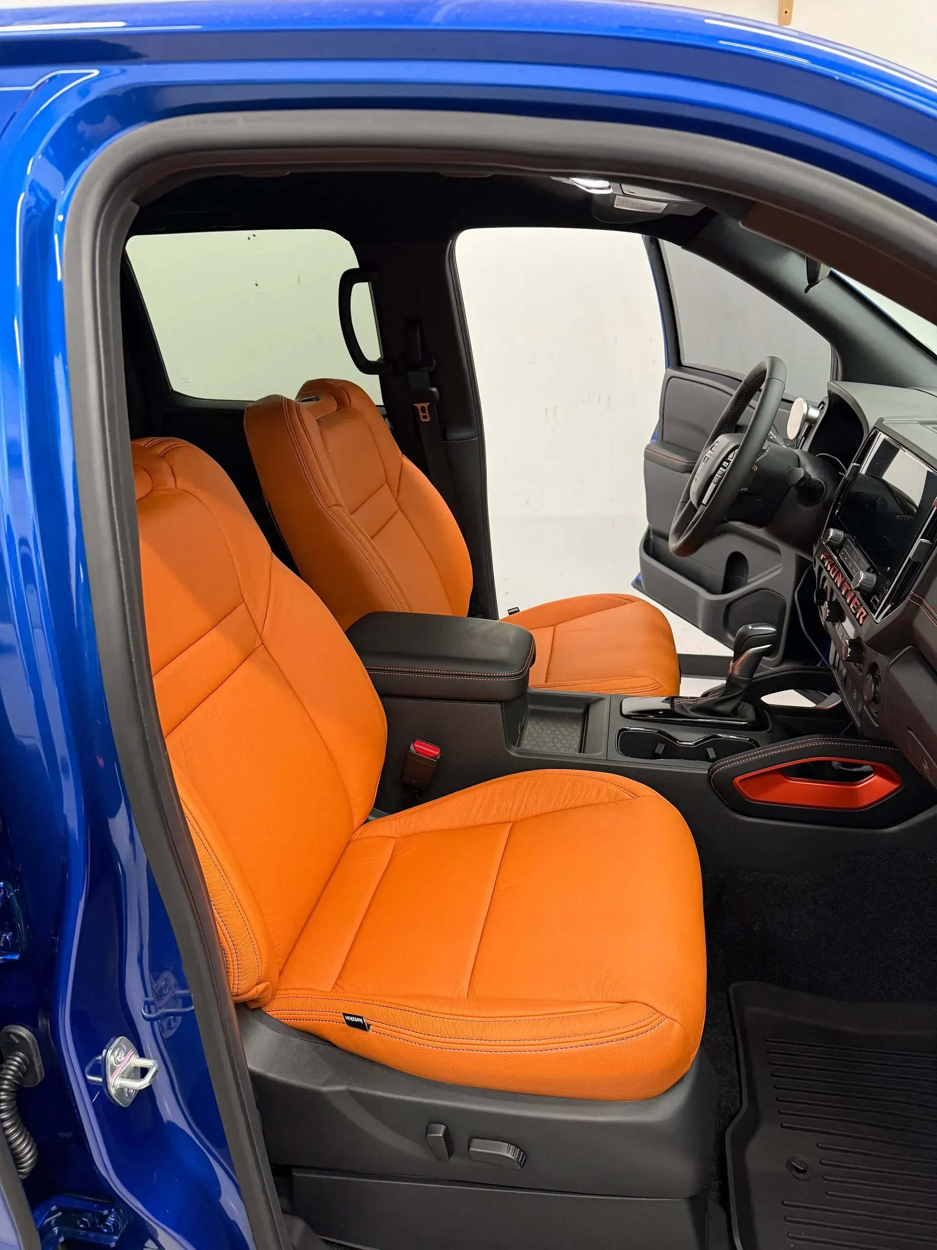 Orange leather seats inside a blue truck.