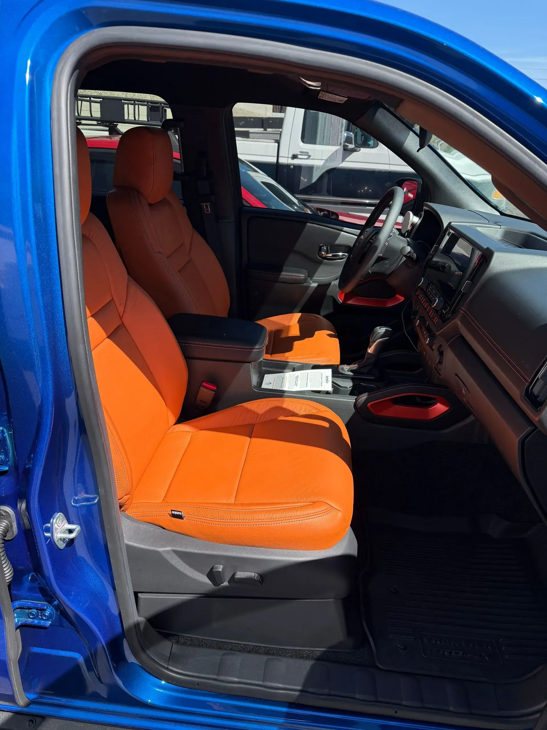 Blue truck interior with bright orange seats and black accents.