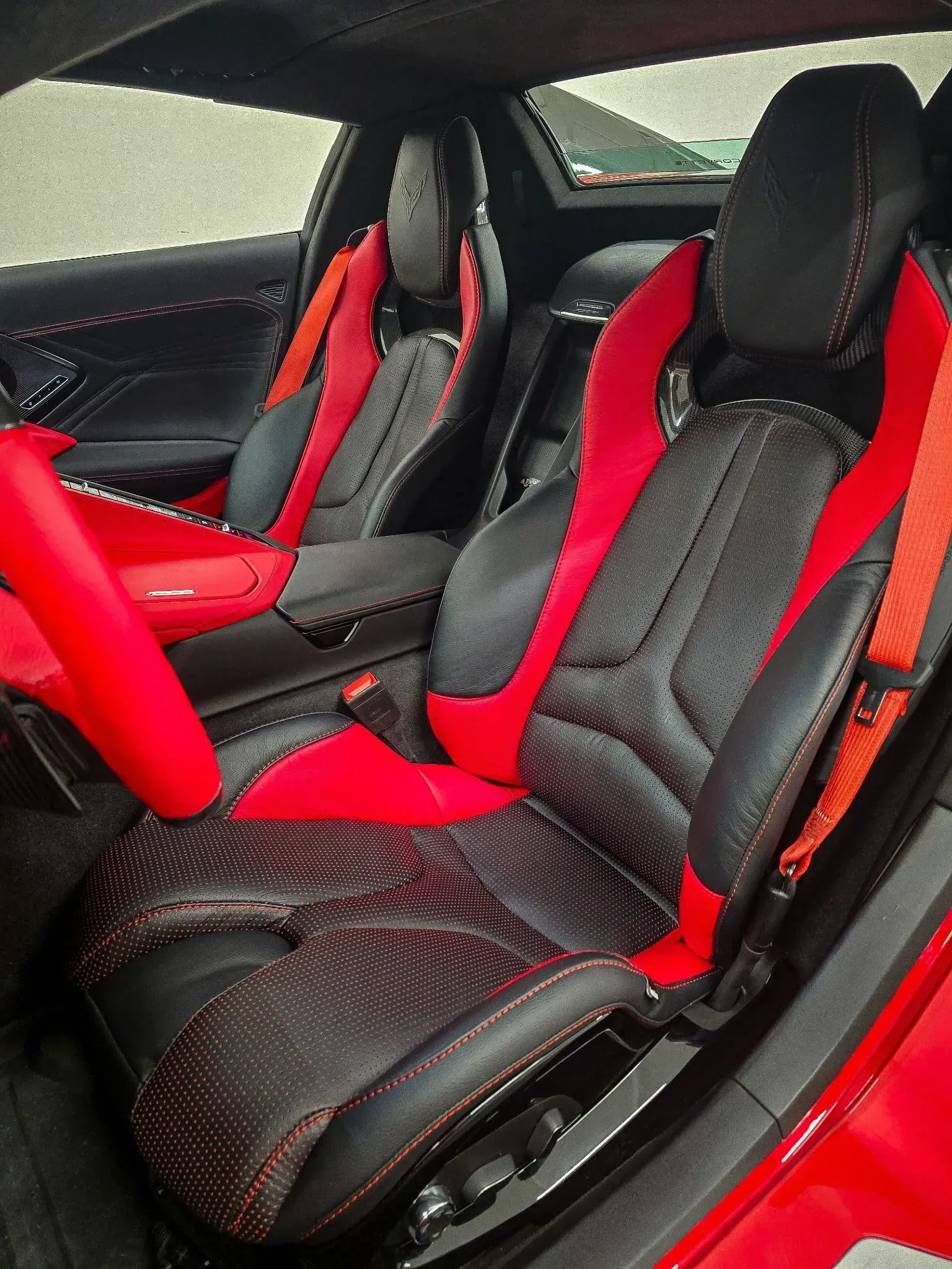 Red and black car interior with bucket seats; red steering wheel and accents.