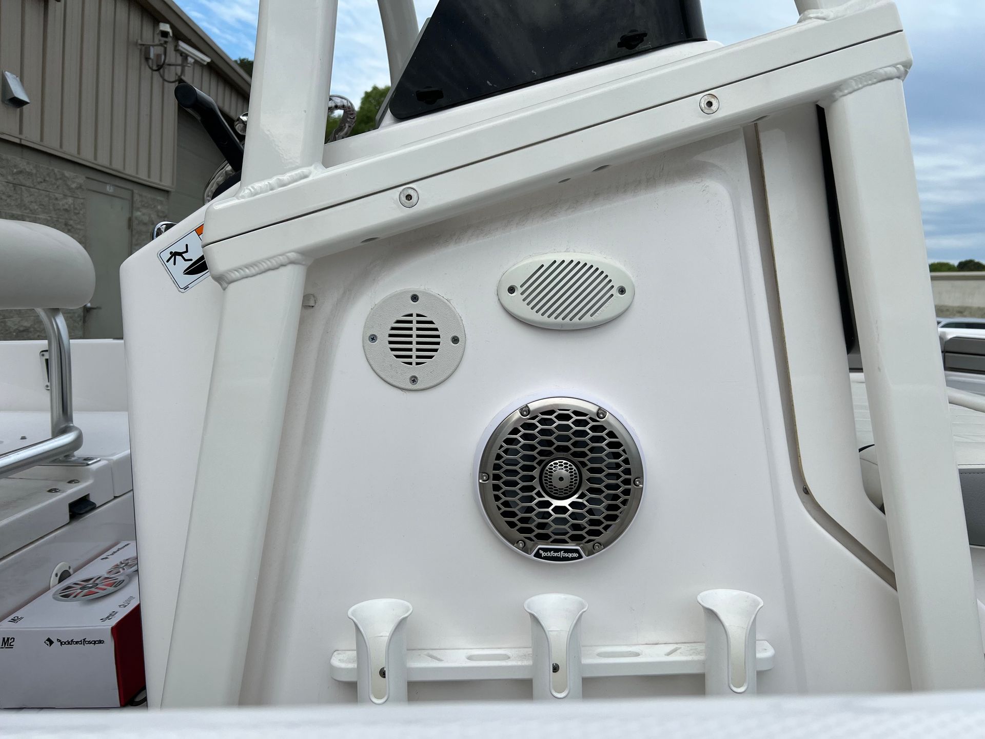 White boat console with three speakers and rod holders.