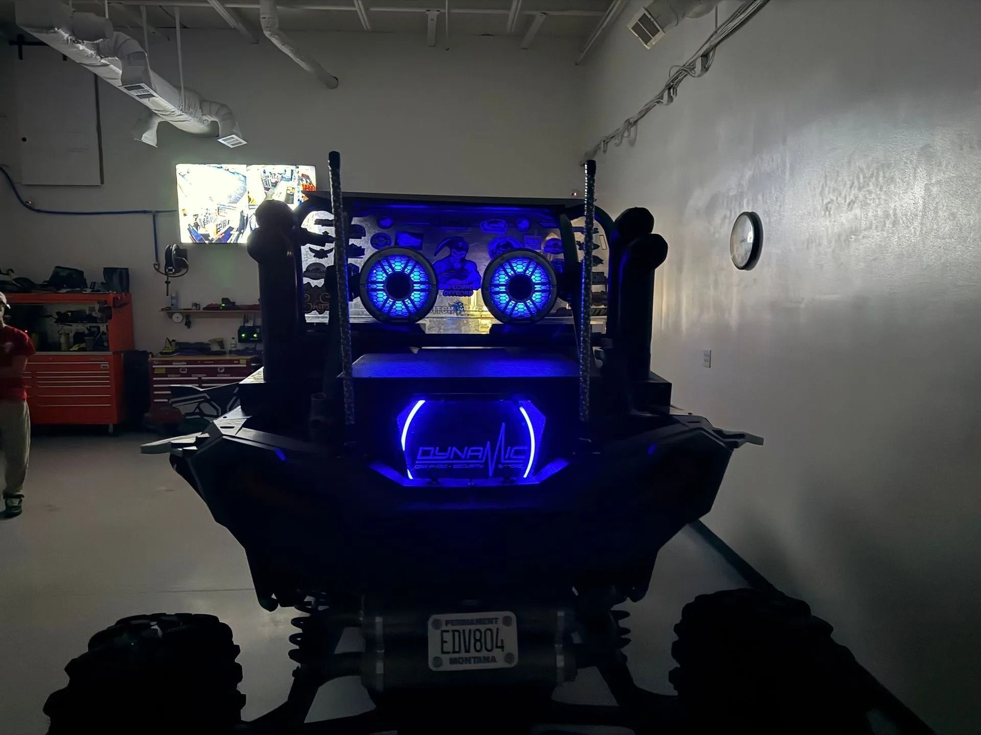 Rear view of a black ATV with blue LED lights. Indoors, in a garage.