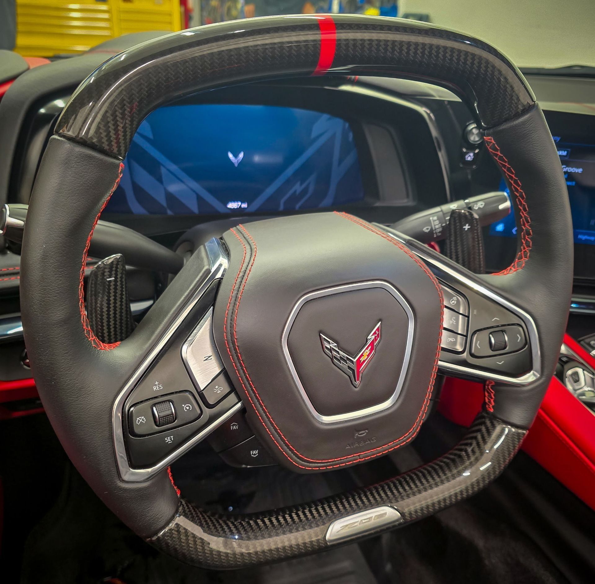 Close-up of a black and red carbon fiber steering wheel in a Corvette.