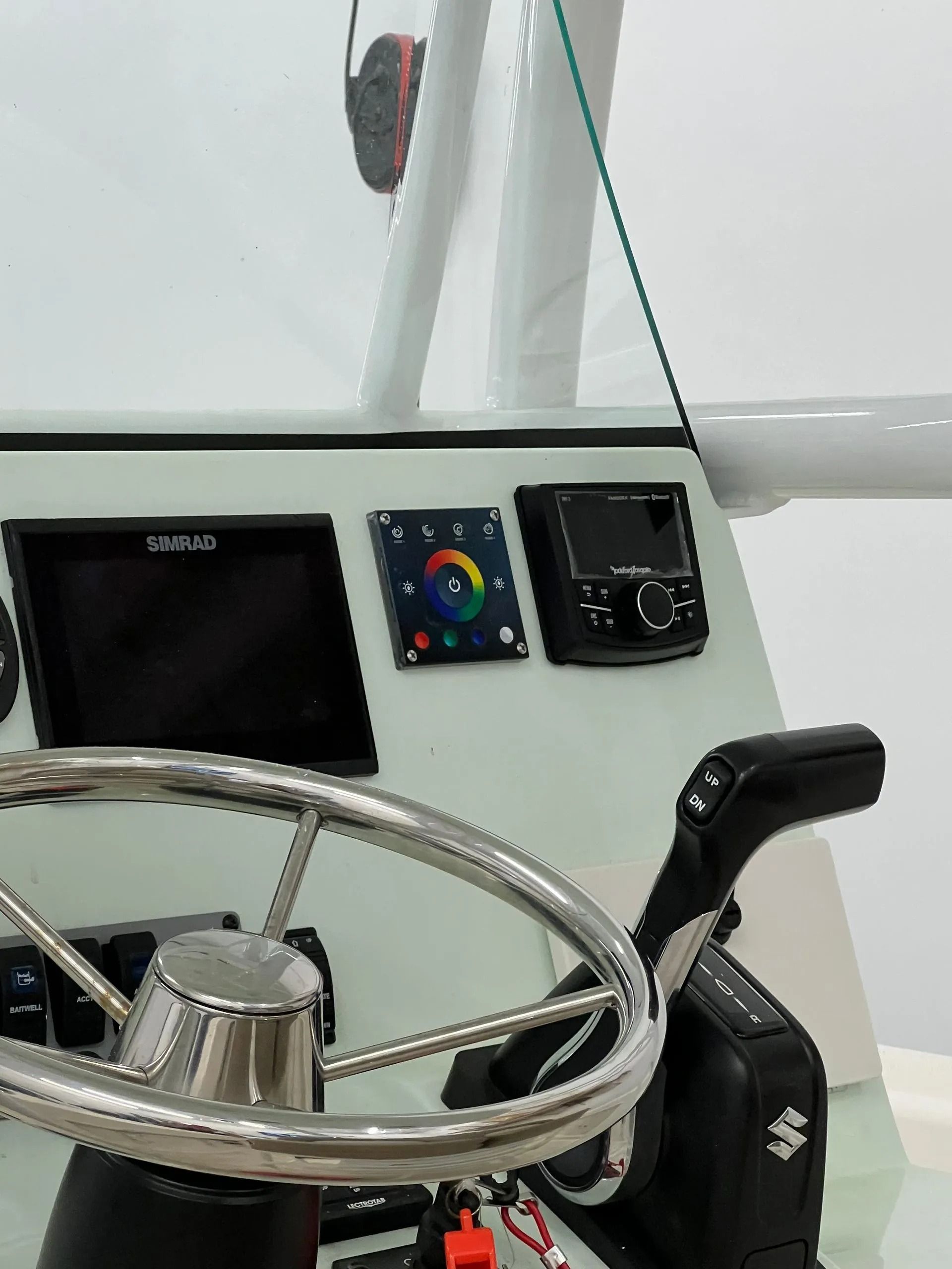 Boat dashboard with steering wheel, navigation screens, and gear shift.