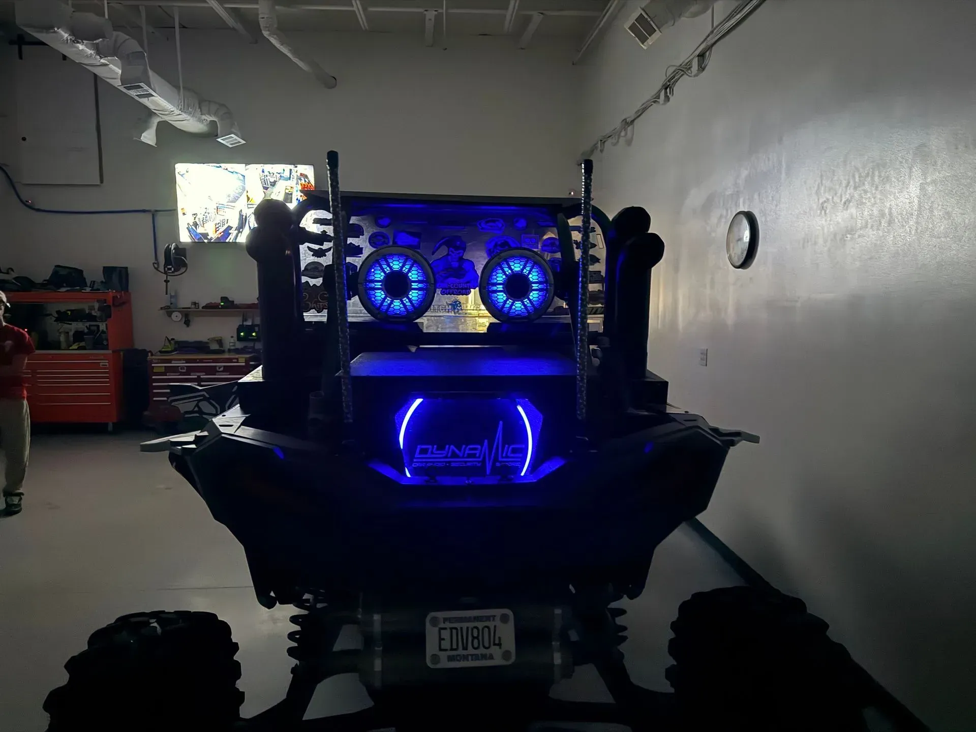 Back of a black ATV with blue glowing lights in a garage setting.
