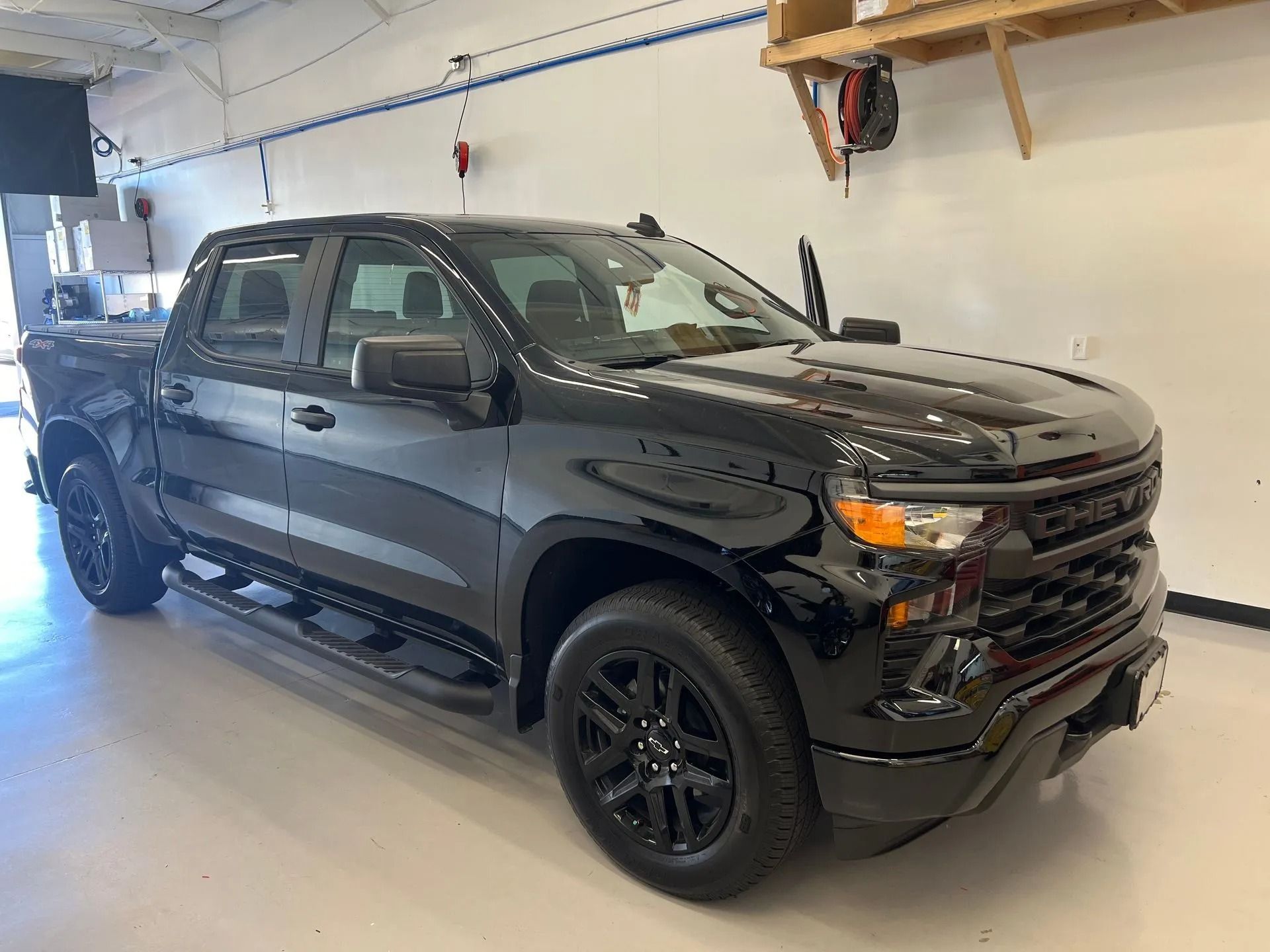 Black Chevrolet Silverado pickup truck parked in a garage.