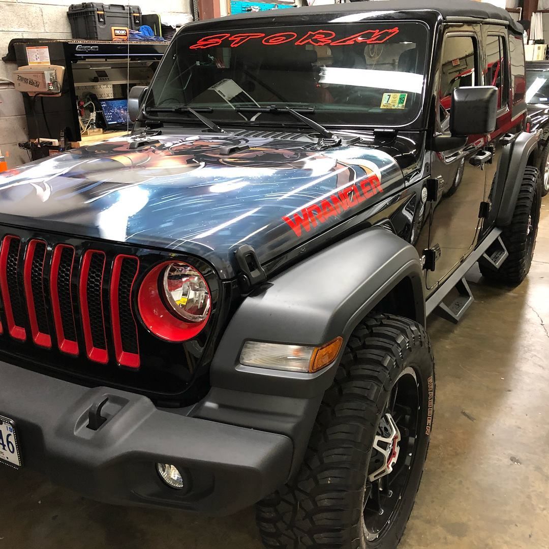 Black Jeep with red accents, parked indoors.