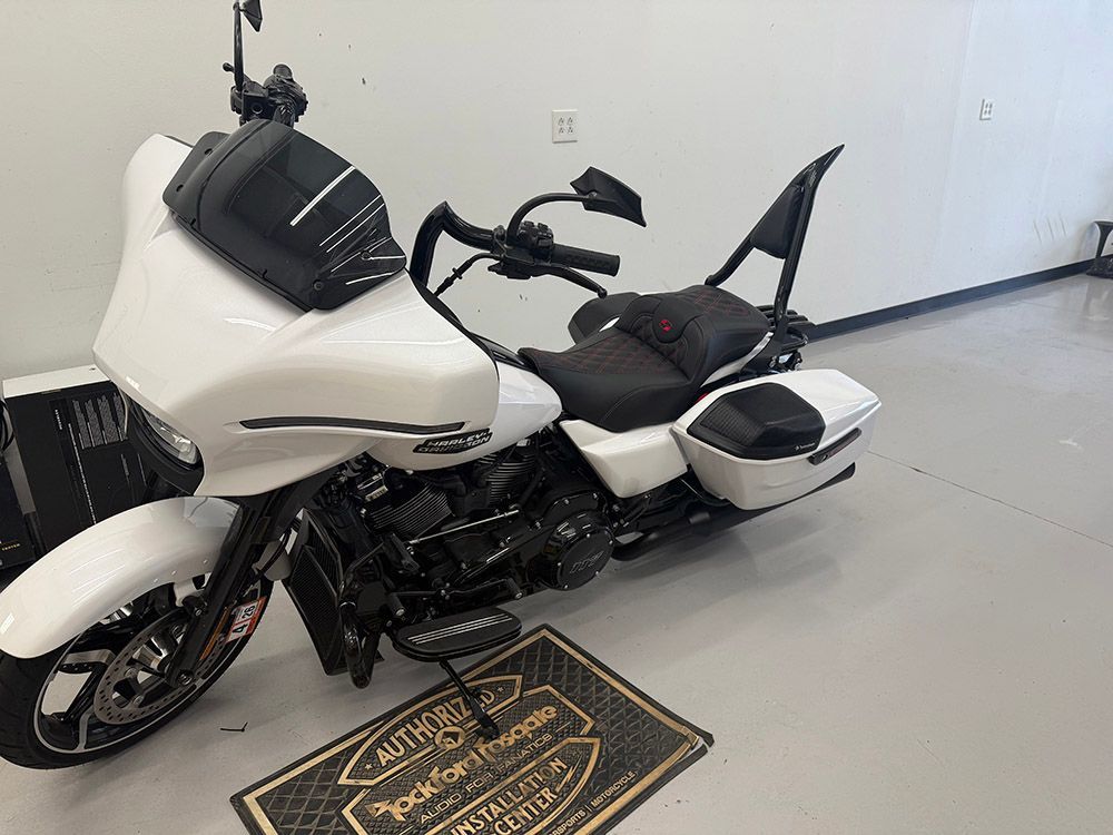 White Harley-Davidson motorcycle with black accents, parked indoors.